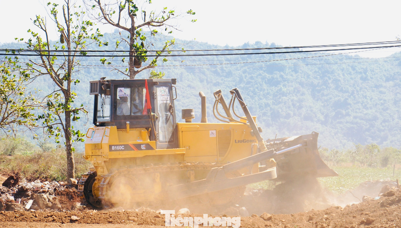 Công nhân điều khiển xe san gạt mặt bằng để thi công nền đường.