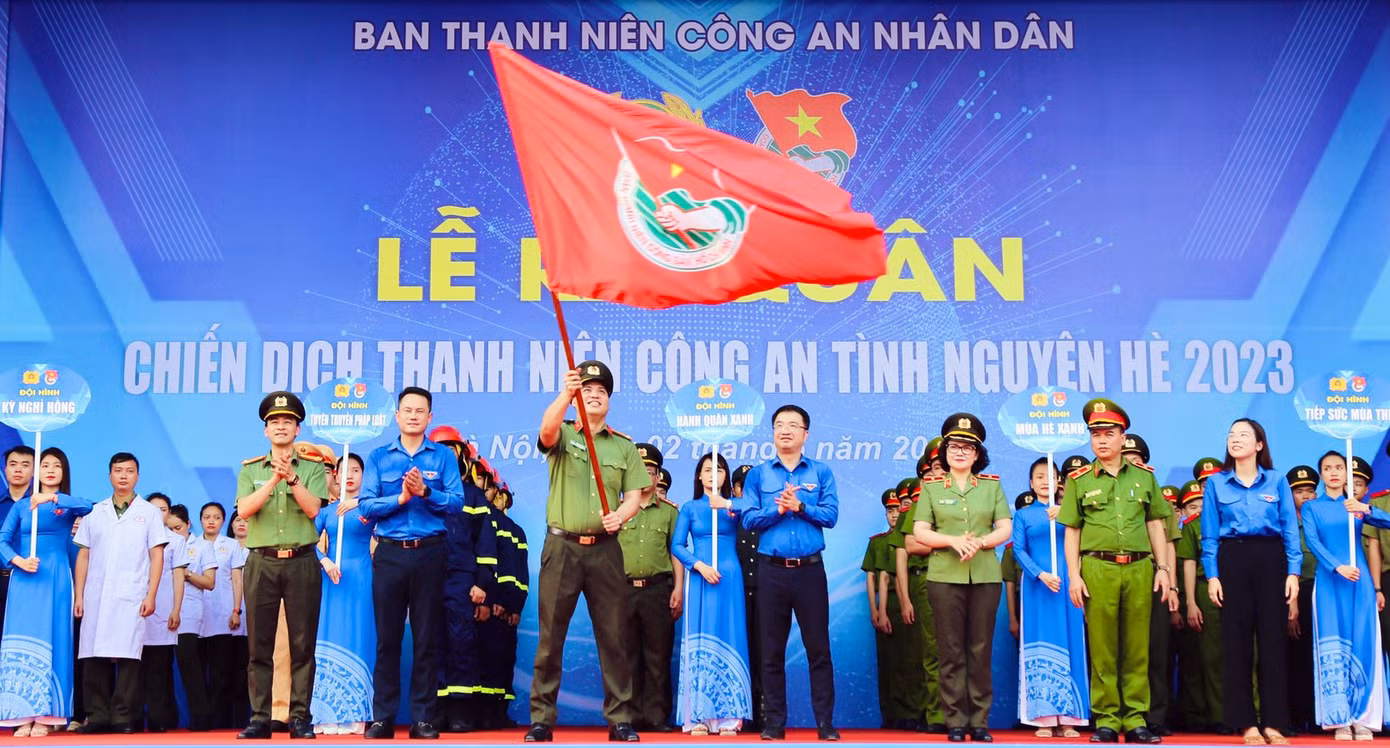 Các đại biểu thực hiện nghi thức trao cờ lệnh ra quân phát động Chiến dịch thanh niên Công an tình nguyện Hè năm 2023. Ảnh: BTC
