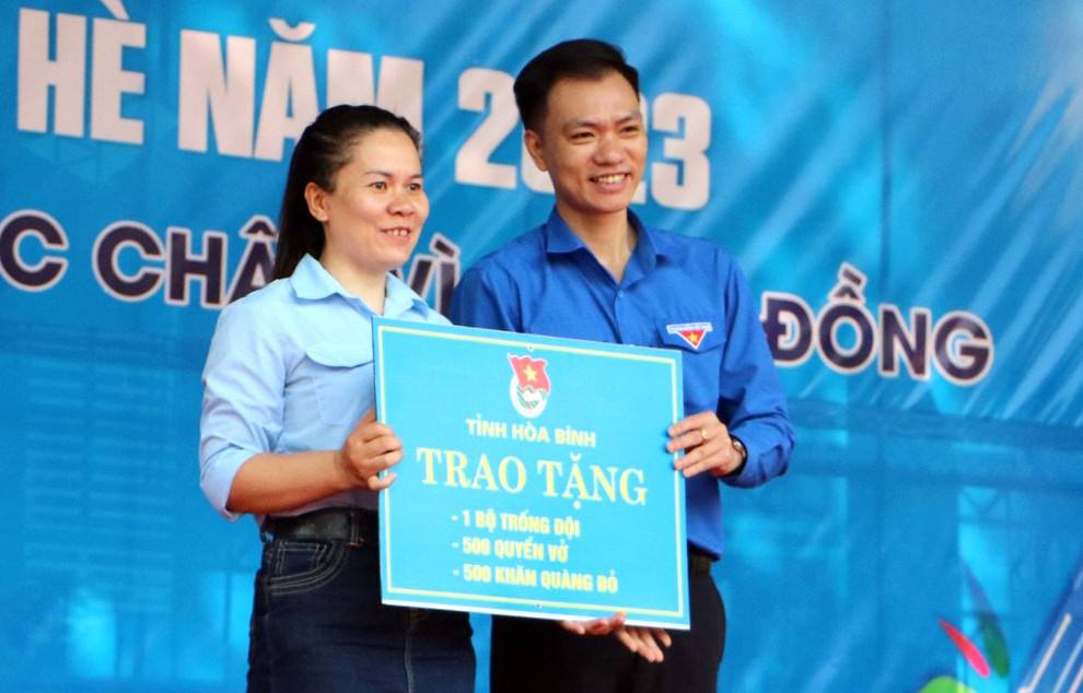 Anh Nguyễn Hoàng Sơn trao biển tượng trưng tặng tặng Liên đội trường Tiểu học và THCS Tòng Đậu. Ảnh: BTC
