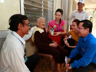 Tổng Biên tập báo Tiền Phong Lê Xuân Sơn (bên phải) thăm hỏi cụ bà cao tuổi nhất Trung tâm Phụng dưỡng người có công với Cách mạng.
