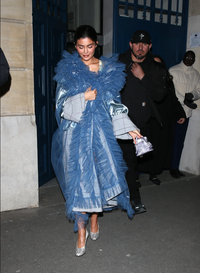 Vẻ ngoài được hoàn thiện với đôi giày lấp lánh và một chiếc túi mini của nhà Maison Margiela. Vẻ ngoài được hoàn thiện với đôi giày lấp lánh và một chiếc túi mini của nhà Maison Margiela.