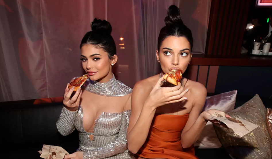 Kylie và Kendall Jenner chọn đăng một bức ảnh đang ăn bánh pizza trong hậu trường. Kylie và Kendall Jenner chọn đăng một bức ảnh đang ăn bánh pizza trong hậu trường.