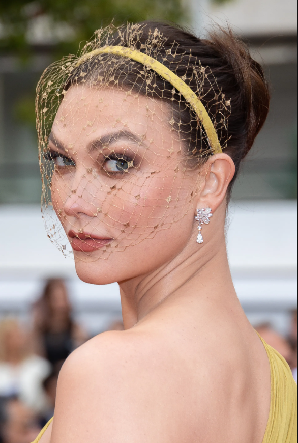 Thiên thần Victoria's Secret Karlie Kloss rạng rỡ với son cam đất và mạng che mặt mỏng tạo hiệu ứng tăng thêm vẻ đẹp ẩn hiện.