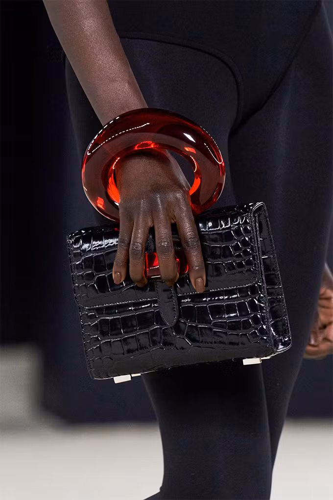 Sự sang trọng và xa cách của chất liệu này đã được Ferragamo giảm xuống bằng cách phủ bóng và thiết kế hình khối.