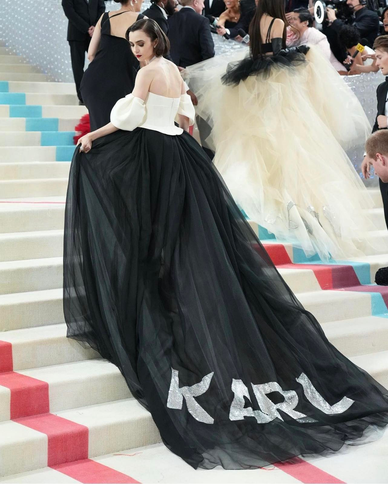 Khoảnh khắc đẹp đến nao lòng của LiLy Collins. Tà váy phủ bậc thang và tên Karl bằng kim sa phía sau vừa đẹp lộng lẫy vừa tôn kính NTK quá cố. Đây dự đoán sẽ là khoảnh khắc đi vào lịch sử Met Gala.