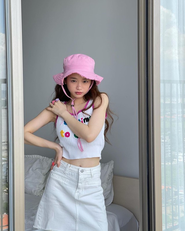 Linh Ka dễ thương khi mặc tank top dệt kim và chân váy ngắn denim.