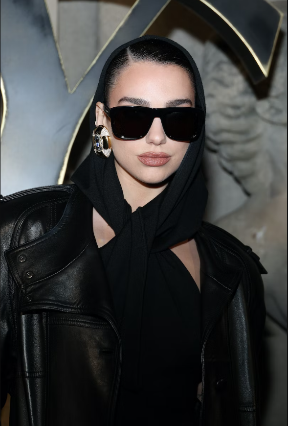 Nữ ca sĩ mặc toàn đồ đen, càng nổi bật đôi hoa tai bằng bạc. Bảng trang điểm của cô ấy là những tông màu tự nhiên được tô điểm bằng một đôi mắt khói. Nữ ca sĩ mặc toàn đồ đen, càng nổi bật đôi hoa tai bằng bạc. Bảng trang điểm của cô ấy là những tông màu tự nhiên được tô điểm bằng một đôi mắt khói.