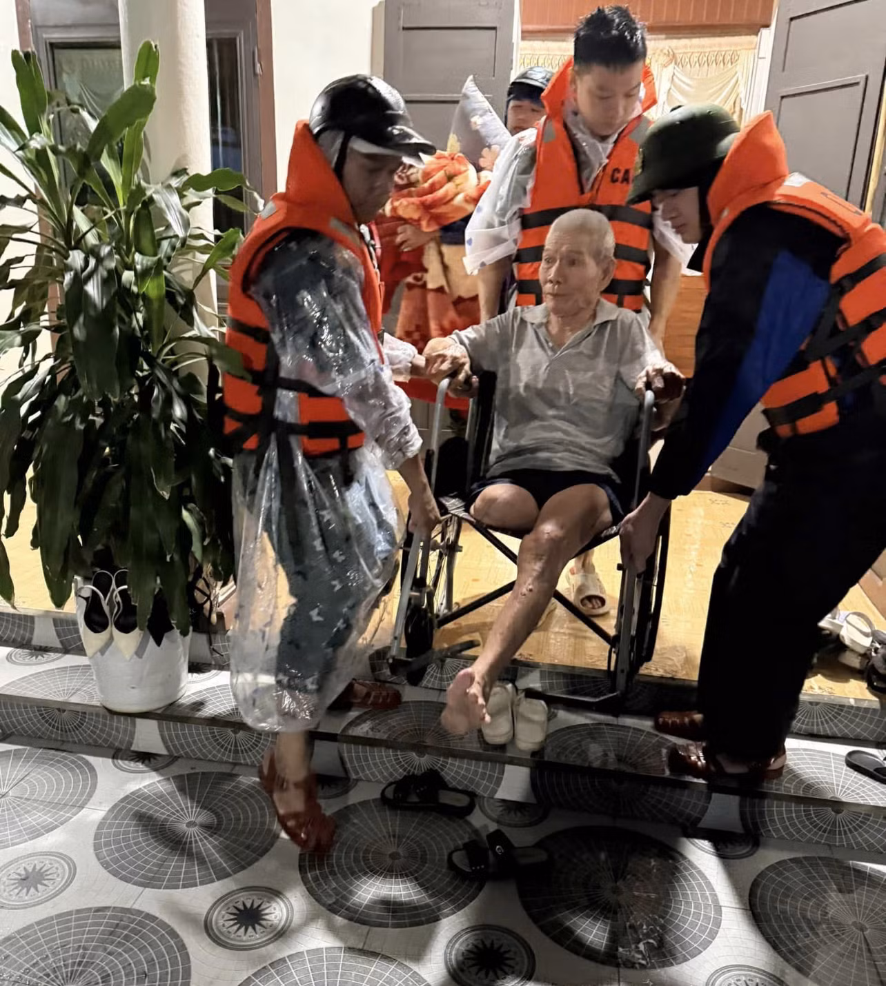 Lực lượng chức năng hỗ trợ sơ tán người già đến nơi cao để tránh ngập lụt