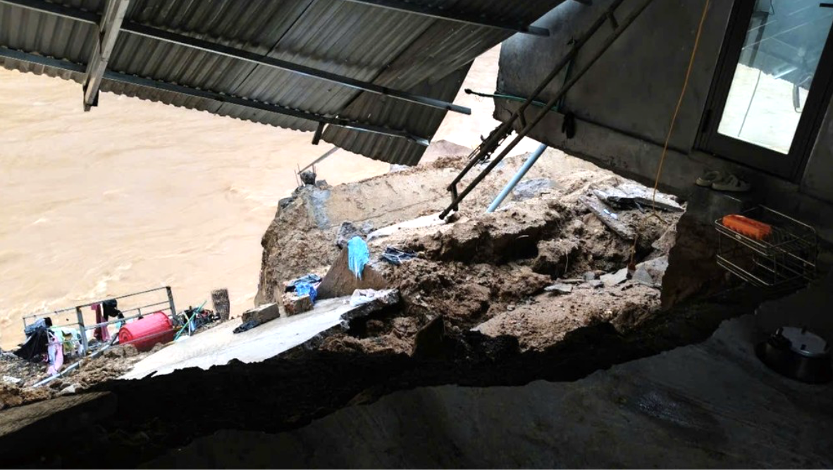 Căn nhà bị sập, nghiêng ra phía bờ suối. Ảnh: BP Căn nhà bị sập, nghiêng ra phía bờ suối. Ảnh: BP