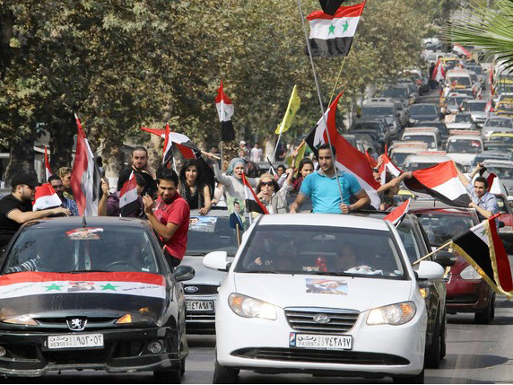 Người dân Syria vẫy cờ khi Liên đoàn Ả rập tới Syria. Ảnh: Getty Images