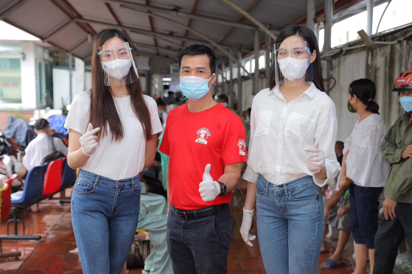 Hai người đẹp phát nhu yếu phẩm cho người dân nghèo.