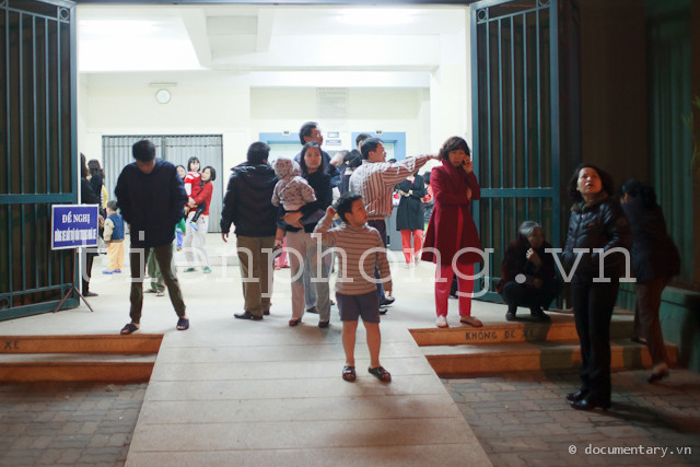 Nhiều gia đình ở chung cư thuộc khu đô thị Bắc Linh Đàm kéo xuống tầng 1 của toà nhà. Nhiều người tỏ ra lo lắng và liên tục phải trả lời điện thoại hỏi thăm của người thân. Ảnh: Thành Long