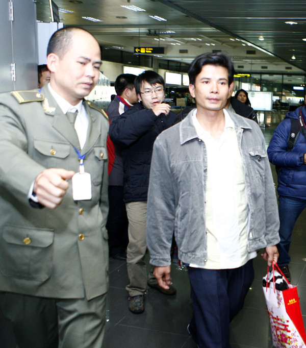 Anh Hùng được lực lượng hộ tống dẫn ra xe taxi