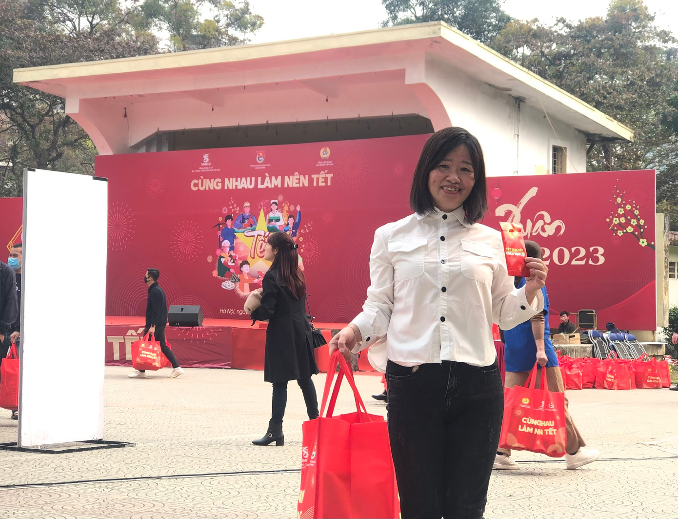 Chị Hoàng Thị Quê vui mừng nhận túi quà và phong bao lì xì từ chương trình "Cùng nhau làm nên Tết". Ảnh: Lưu Trinh