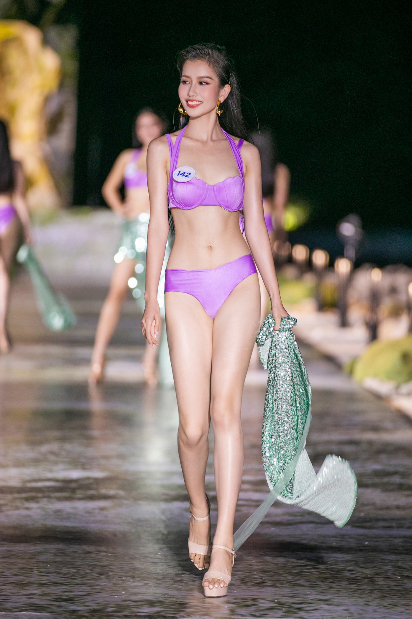 Sau phần mở màn của top 3 Miss World Vietnam 2022, top 40 thí sinh của cuộc thi Hoa hậu Thế giới Việt Nam 2023 bước ra sàn diễn trong trang phục bikini màu tím.