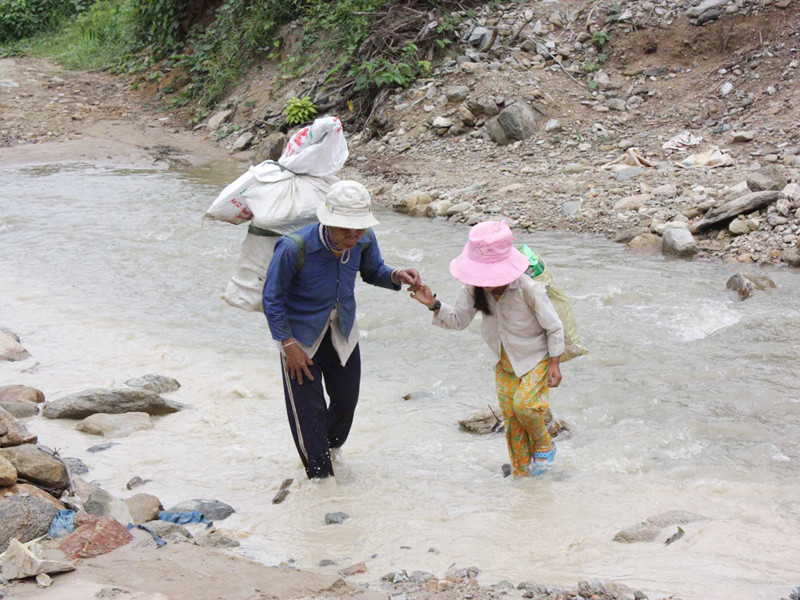 Mẹ con chị Hồ Thị Chùy cõng chuyến dắt díu nhau vượt qua suối 