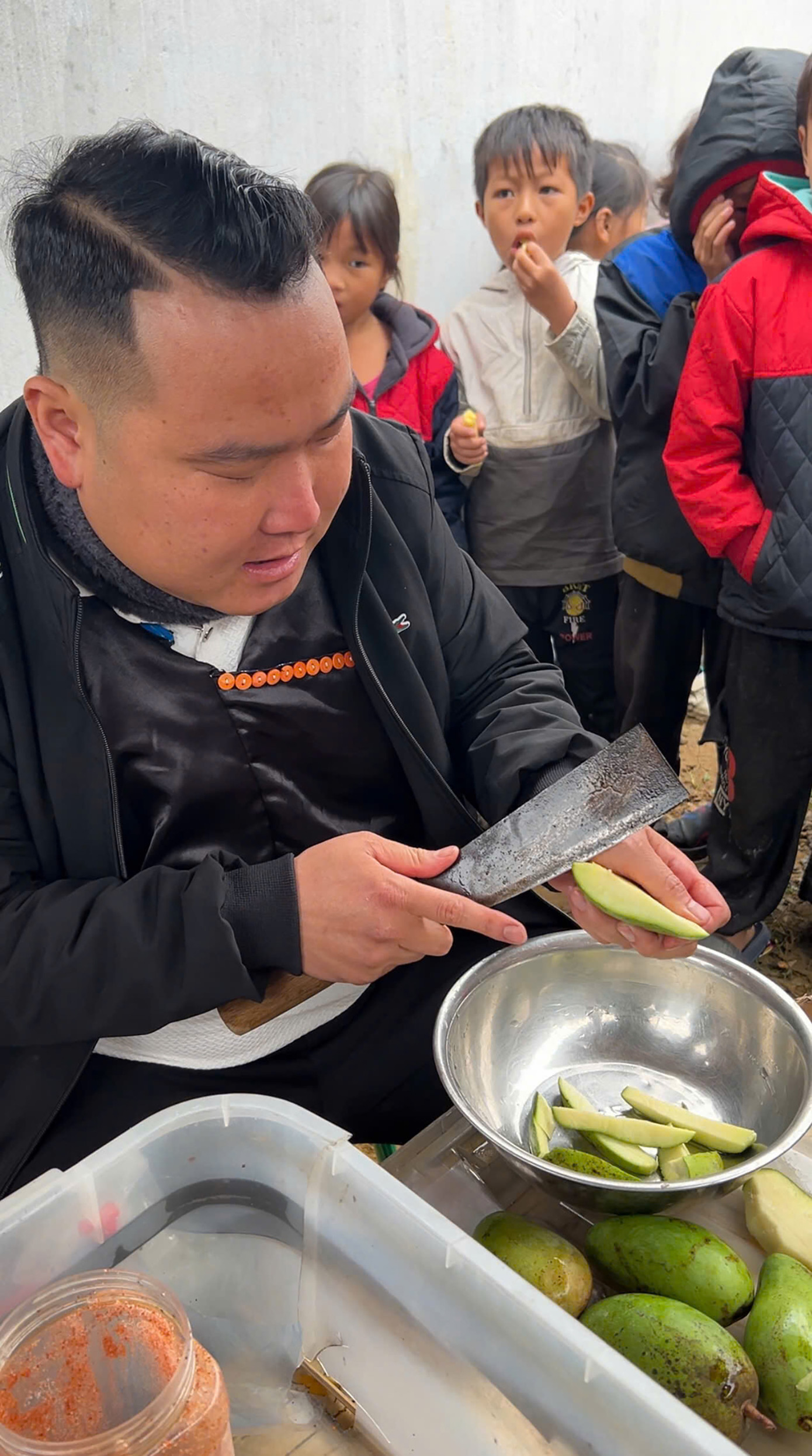 Niềm vui chàng trai dân tộc Mông với các em nhỏ.