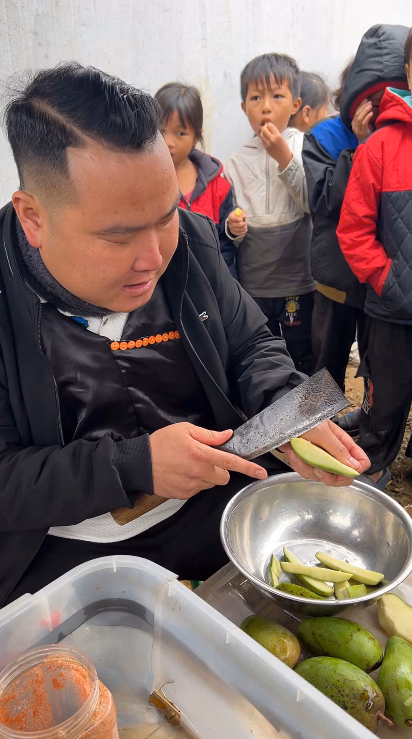 Niềm vui chàng trai dân tộc Mông với các em nhỏ.