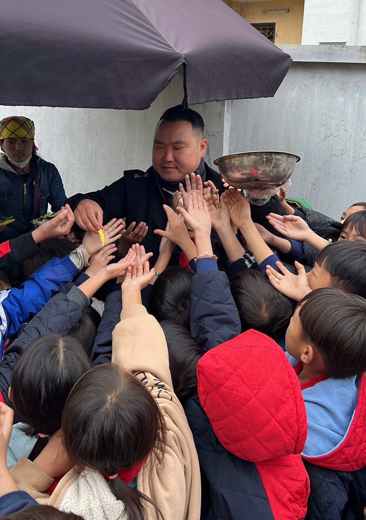 Niềm vui chàng trai dân tộc Mông với các em nhỏ.