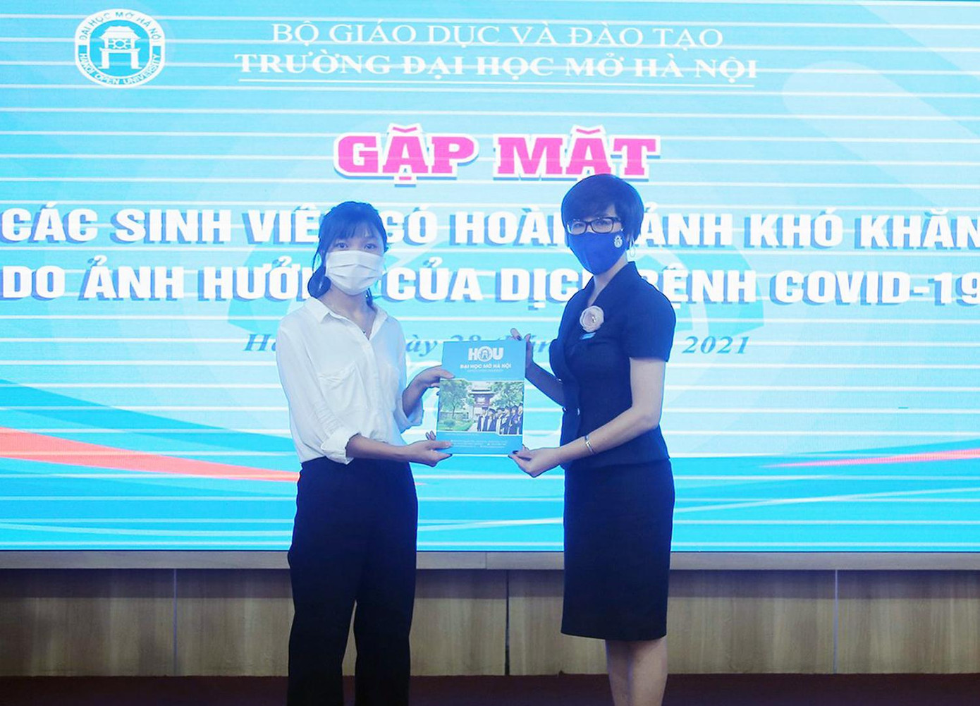 Nguyễn Thị Thành nhận quà hỗ trợ của trường từ Phó Hiệu trưởng Nguyễn Minh Phương.