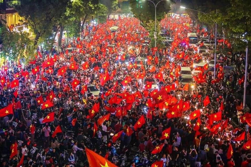 Tại Hà Nội, màu đỏ của lá cờ Tổ quốc hoà cùng âm thanh nô nức của hàng triệu người hâm mộ đổ ra đường.