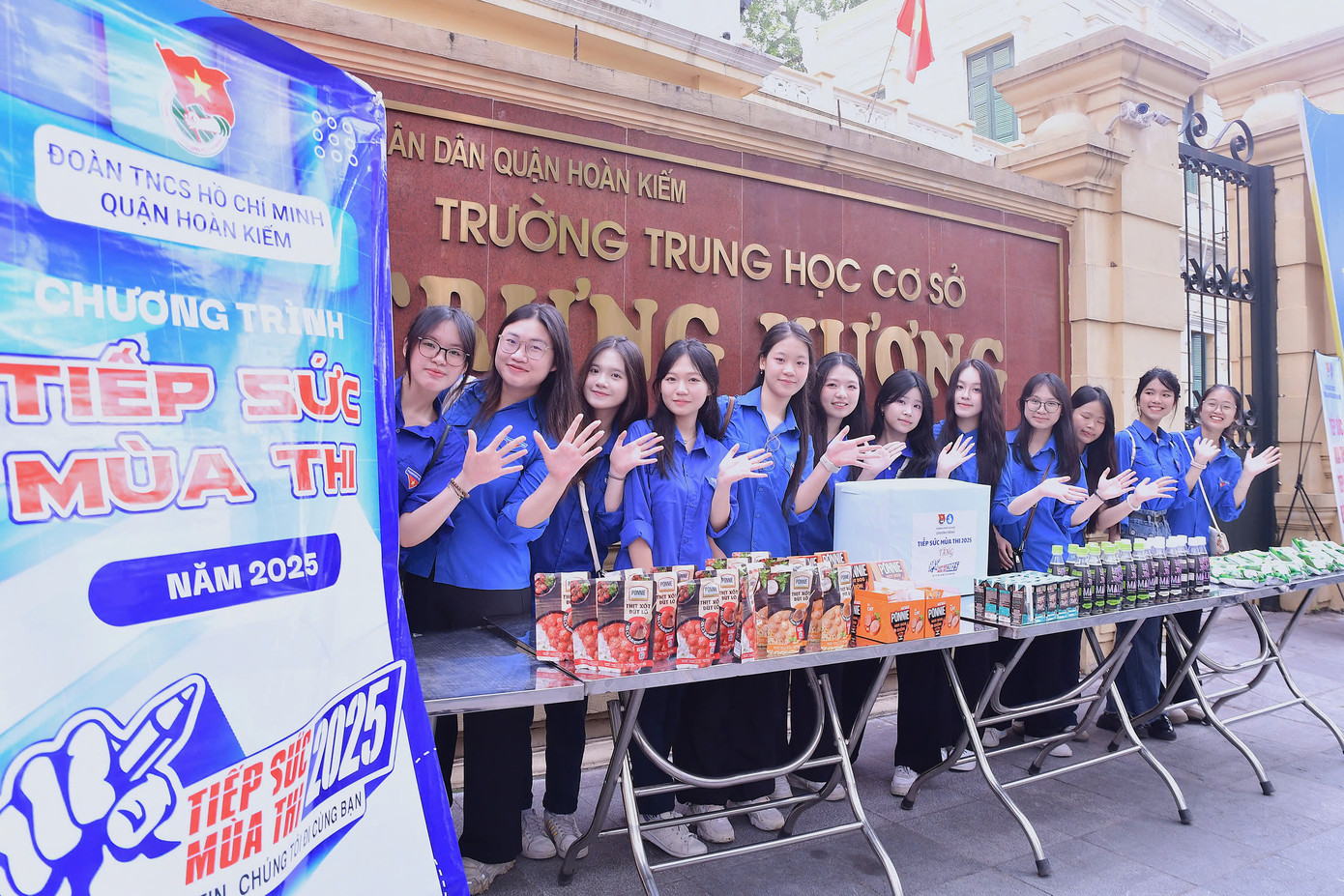 Ghi nhận tại các điểm thi như THCS Minh Khai (Hai Bà Trưng), THCS Trưng Vương (Hoàn Kiếm), THPT Kim Liên (Đống Đa)..., các đội hình tình nguyện của các trường đại học trên địa bàn Thủ đô túc trực từ 5h30 sáng. Khi trời bắt đầu nắng gắt, các tình nguyện viên nhanh chóng chia thành từng nhóm, người phát nước, người chỉ đường, người giơ ô che nắng cho sĩ tử đang đợi vào điểm thi.