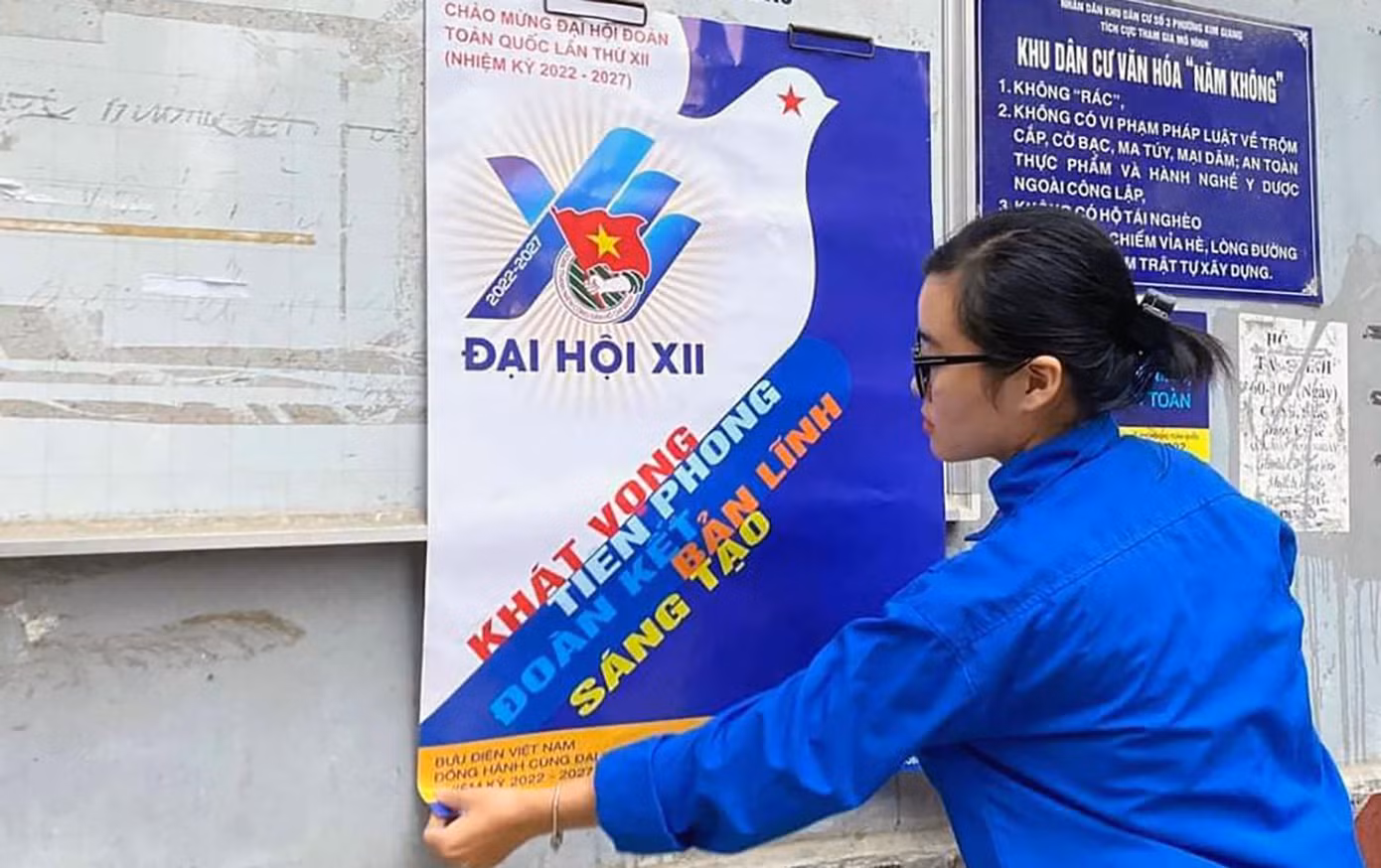 Lực lượng tình nguyện viên hăng hái trang trí trên các bảng thông tin của phường, khu dân cư.