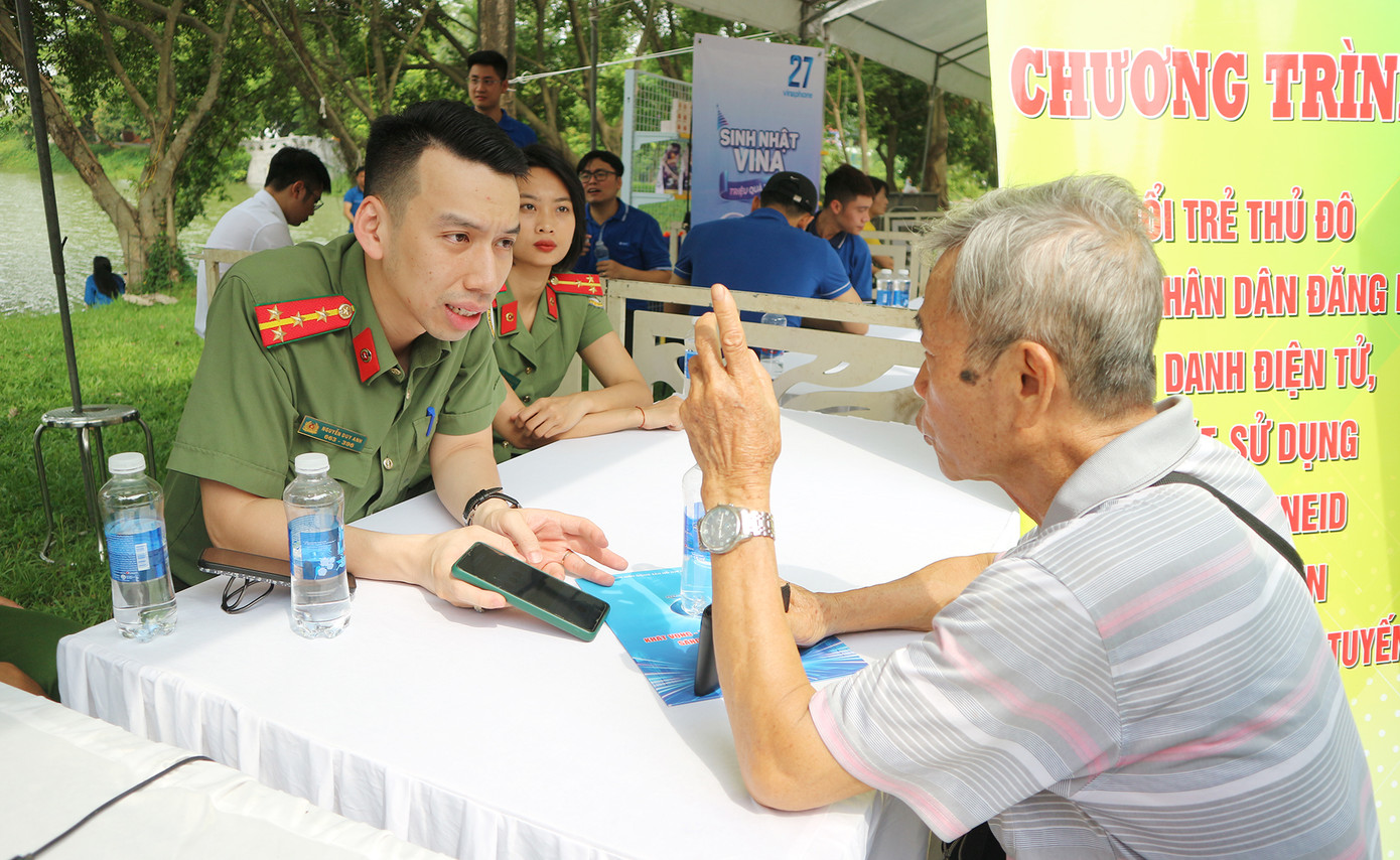 Các chiến sĩ công an Thủ đô hỗ trợ người dân đăng ký, cấp căn cước công dân, hộ chiếu, kích hoạt định danh điện tử.