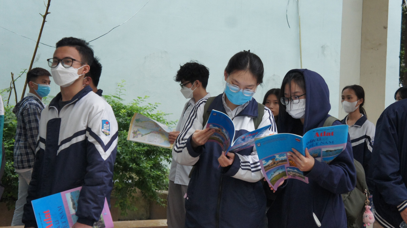 Thí sinh kiểm tra lại thông tin trên Atlat Địa lý trước khi làm thủ tục dự thi HSA 303 tại điểm thi Trung tâm Khảo thí ĐHQG Hà Nội ngày 9/4/2023.