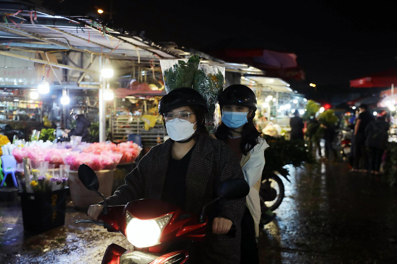Ngoài các tiểu thương, chợ hoa Quảng Bá cũng thường xuyên đón các khách mua lẻ. Trong ảnh là hai cô gái đi mua hoa trong đêm.