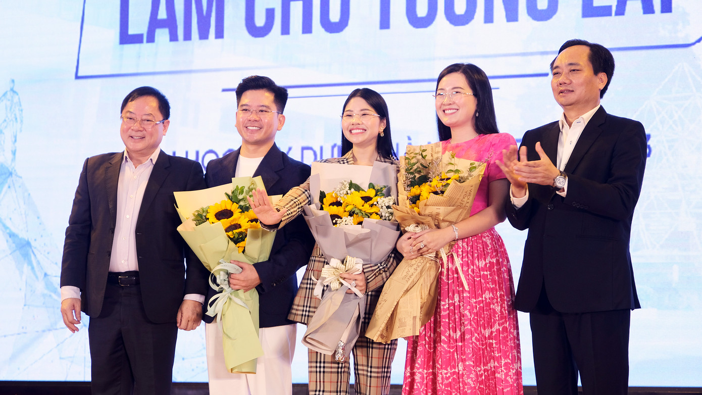 Nhà báo Lê Xuân Sơn (bên trái) và PGS.TS Phạm Xuân Anh (bên phải) tặng hoa cảm ơn diễn giả Lang Công Đạt, chị Nguyễn Diệu Thu, chị Nguyễn Thị Thạch Thảo.