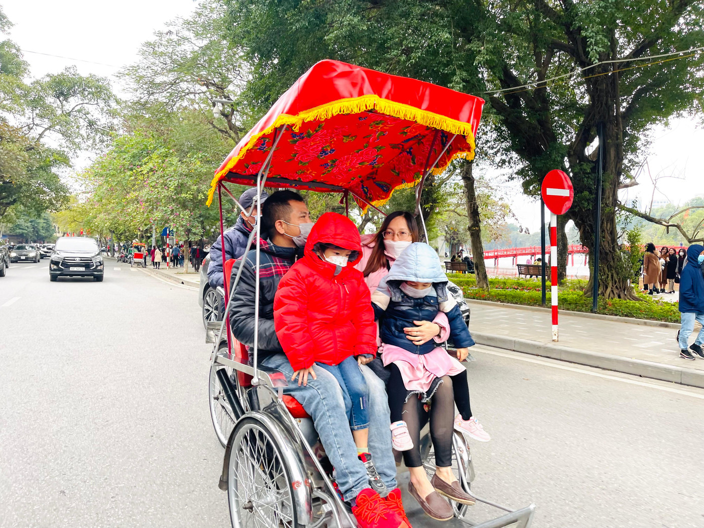 Một gia đình thảnh thơi dạo phố trên chiếc xích lô chiều mùng 2 Tết.