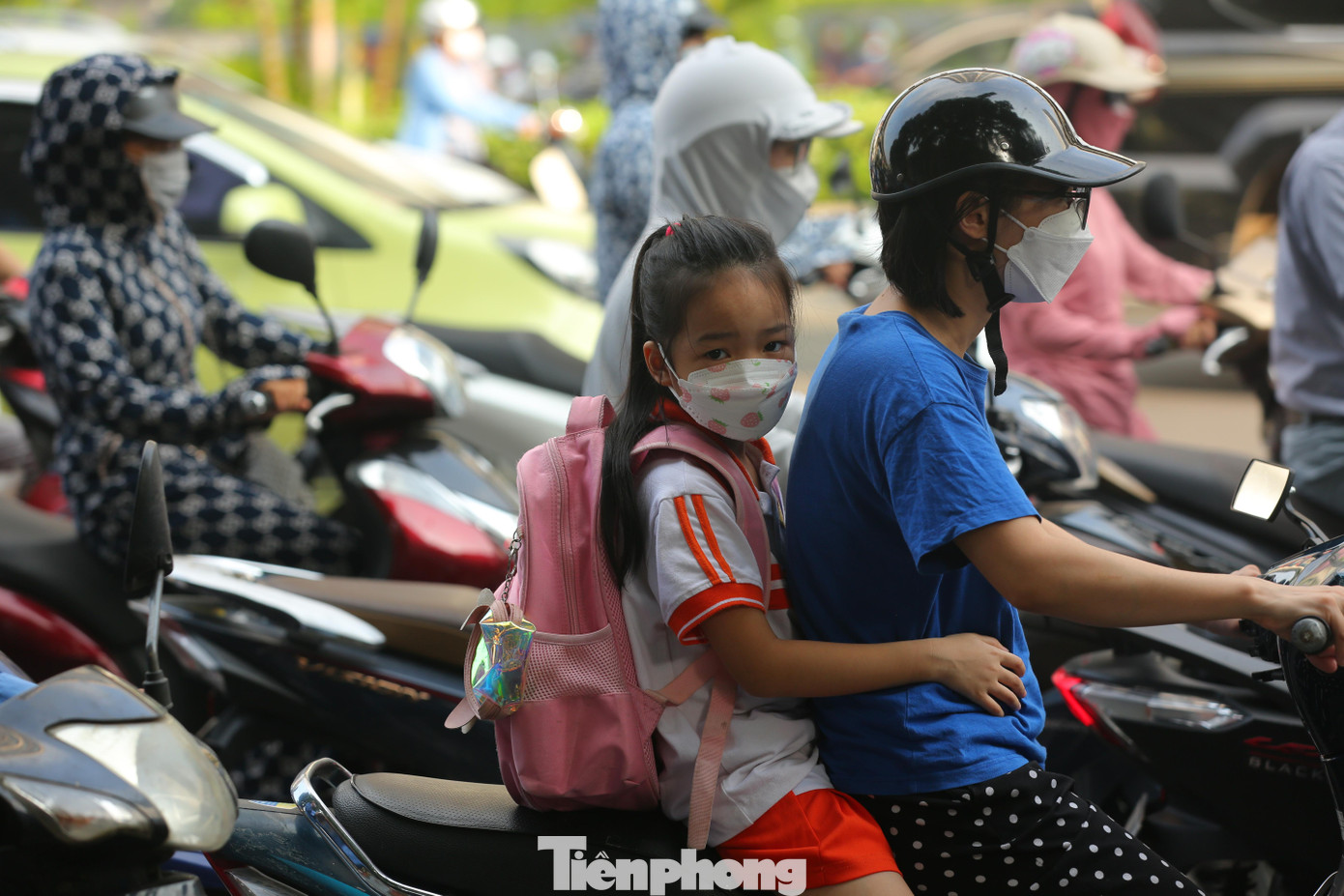 Vẻ mặt mệt mỏi, thẫn thờ của em bé khi cùng mẹ vượt quãng đường ùn tắc kéo dài để đến trường.