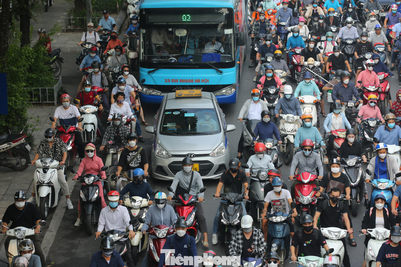 Taxi bị bủa vây bởi hàng chục xe máy nên không thể chuyển làn đành chấp nhận đi vào làn đường dành riêng cho xe máy.