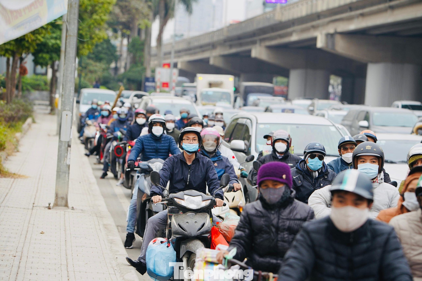 Người dân lỉnh kỉnh đồ đạc trên đường về quê nghỉ ăn Tết.