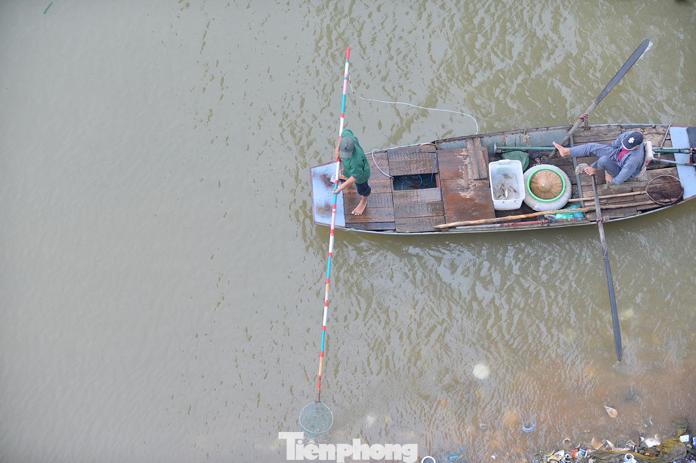 Phía dưới chân cầu, cá chưa kịp bơi đi xa đã có thuyền của người dân đi 'trục vớt'.