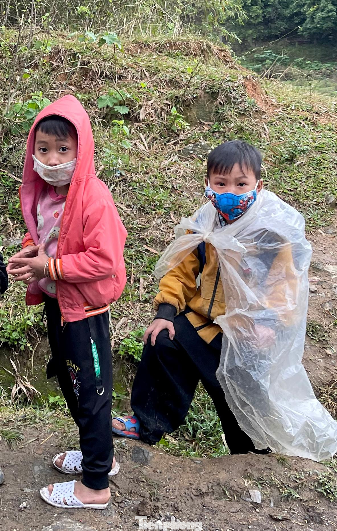 Trời rét buốt lạnh căm căm nhưng các em nhỏ vẫn đi dép lê, choàng áo mưa đi ngoài đường.