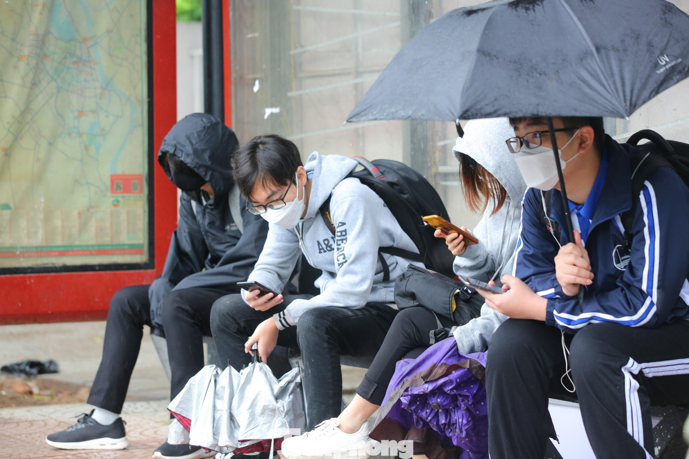 Nhiều bạn trẻ co ro đợi xe tại bến xe buýt trên đường Nguyễn Chí Thanh.