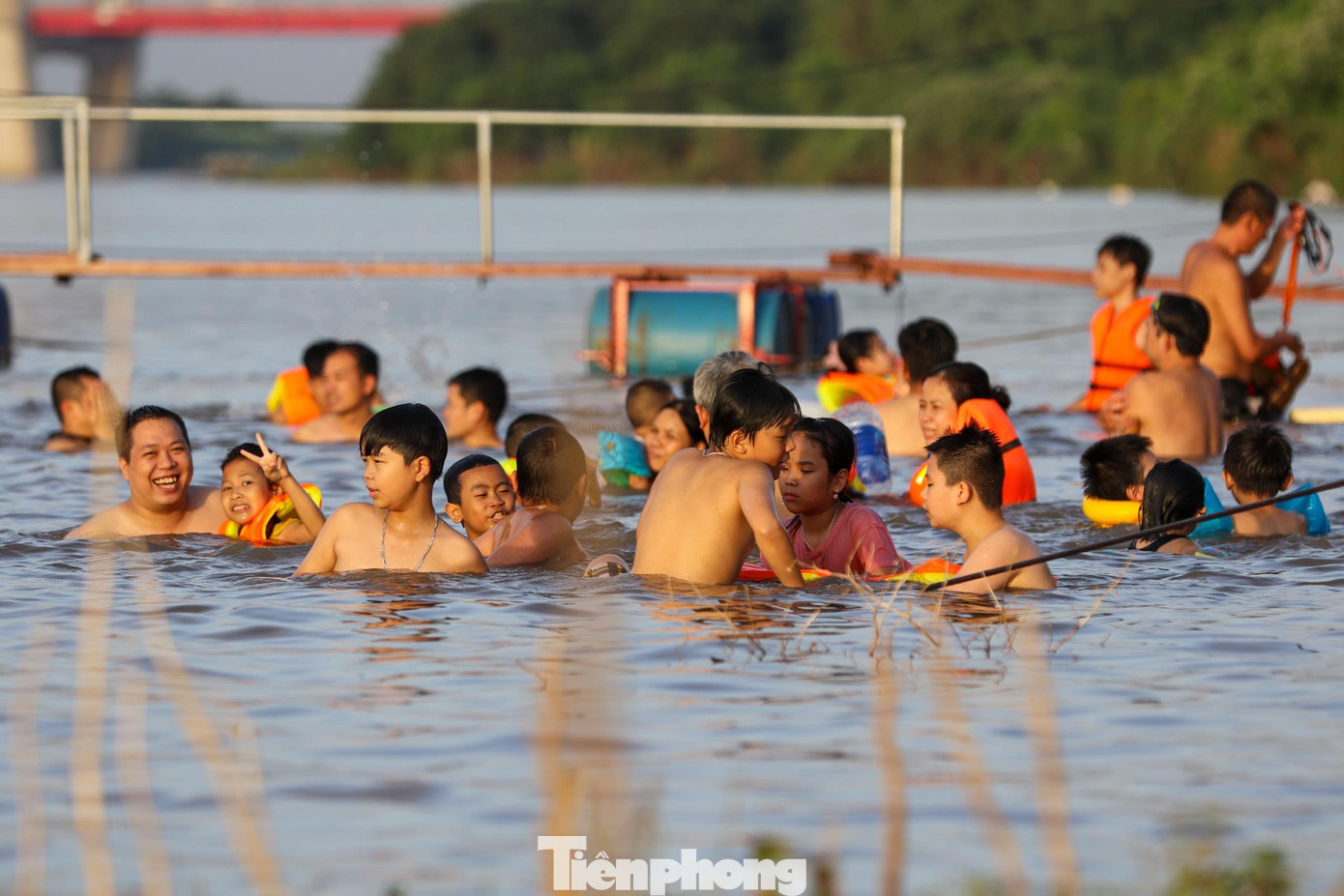 Các em nhỏ hào hứng tập bơi dưới sự giám sát của người lớn.