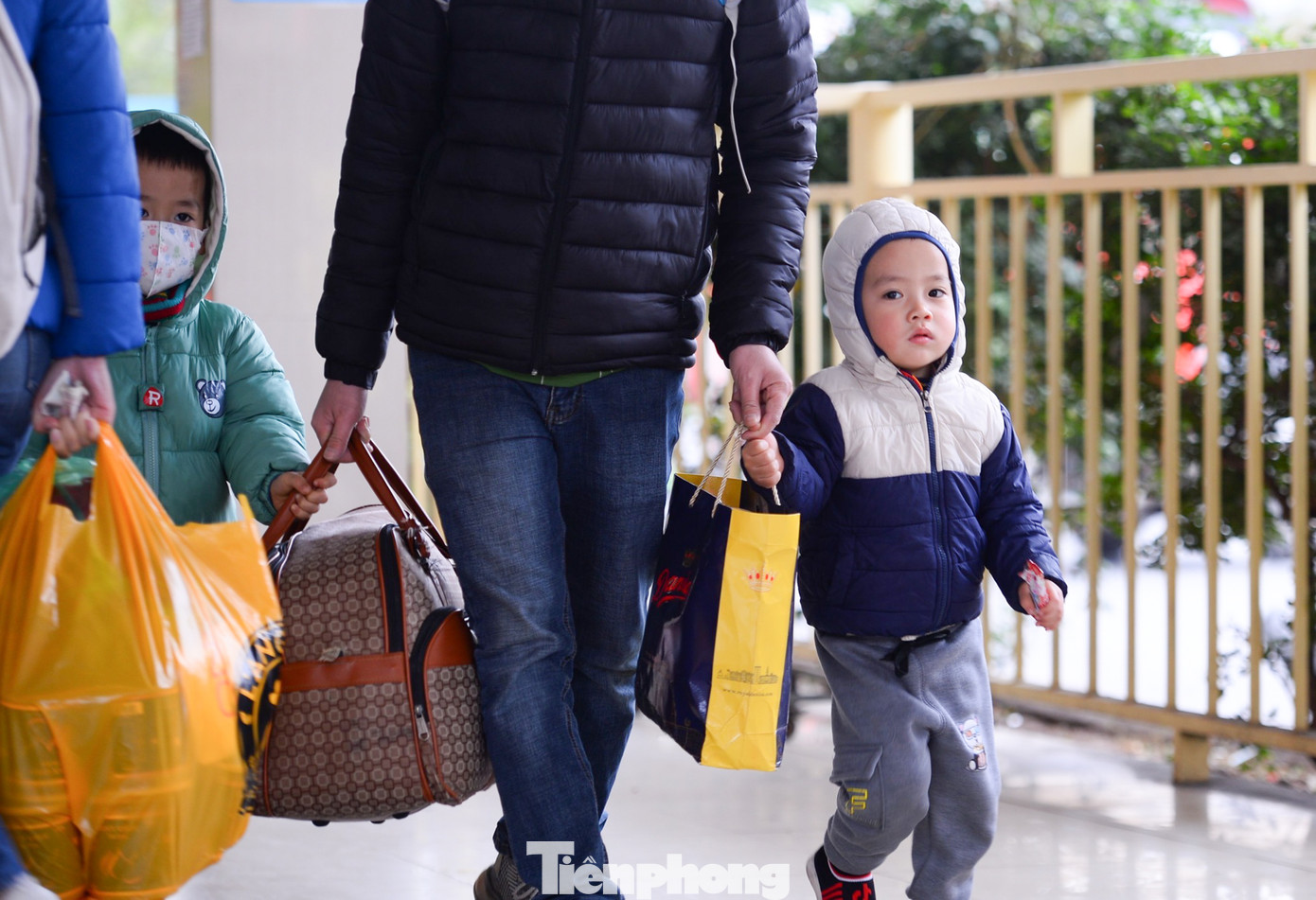 Các em nhỏ theo bố mẹ về quê nghỉ Tết.