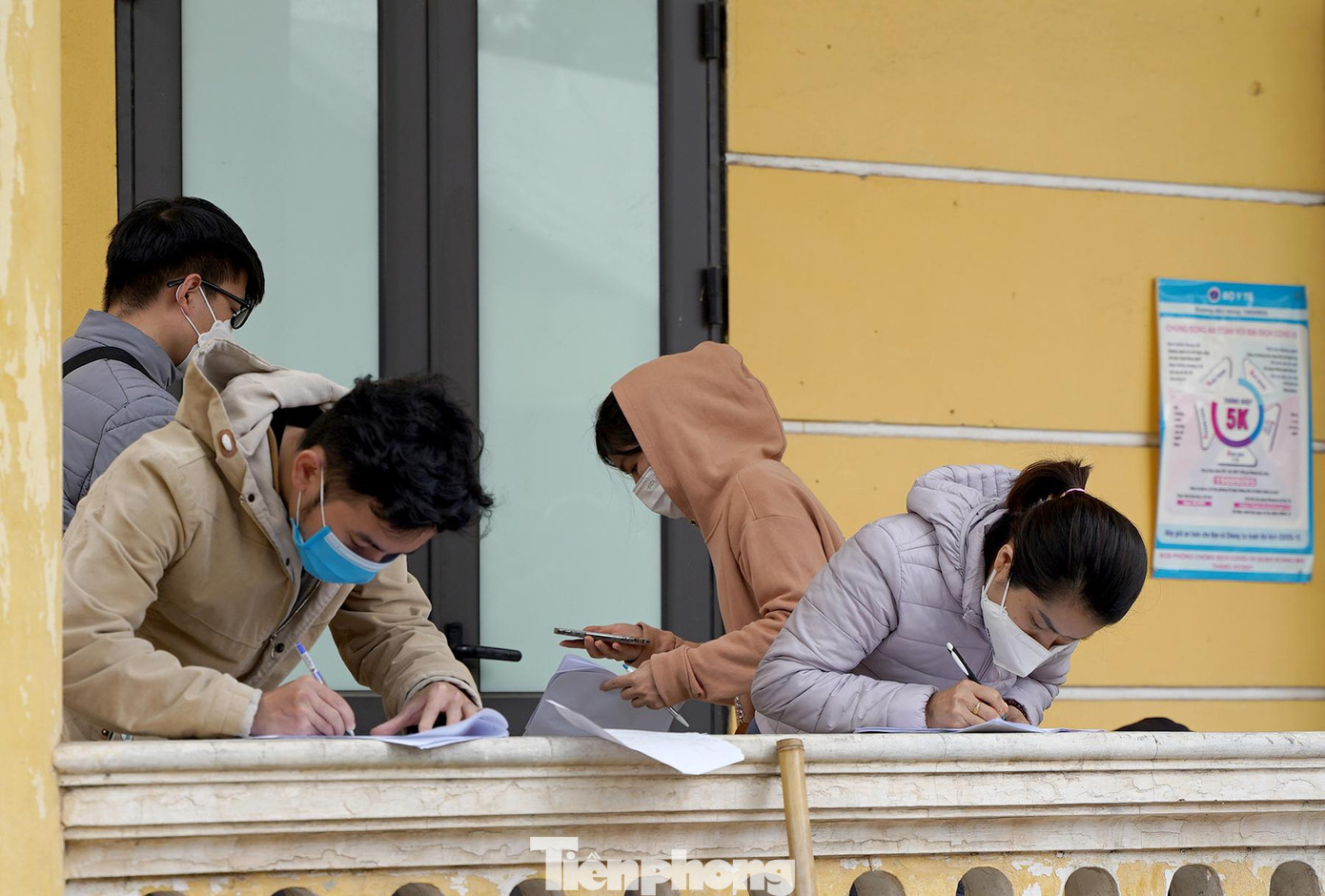 Người dân tranh thủ đứng khai báo y tế dọc hành lang của nhà văn hóa phường Hoàng Liệt.