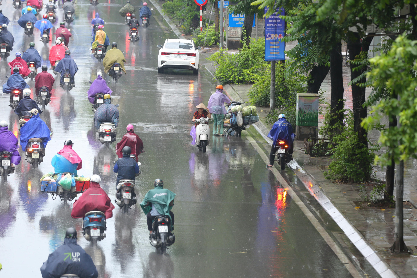 Một người dân bất chấp nguy hiểm di chuyển ngược chiều trong cơn mưa tầm tã sáng nay.