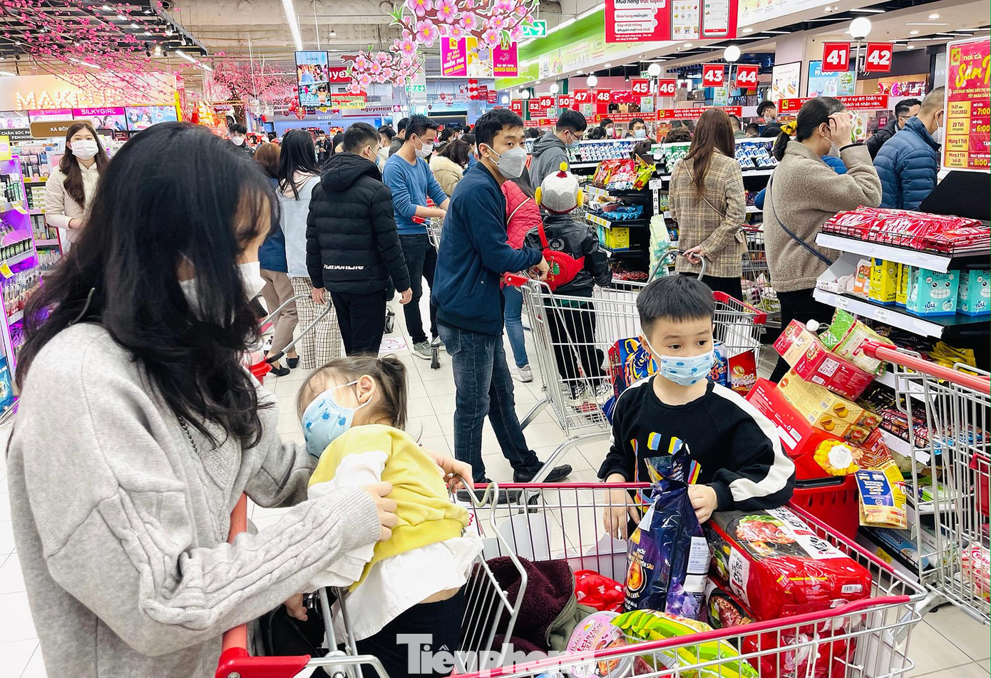 Cảnh chen chân mua bán, đợi chờ đông đúc ngày cận Tết khiến nhiều em bé mệt mỏi, ngủ gục trên tay bố mẹ trong lúc đợi thanh toán.