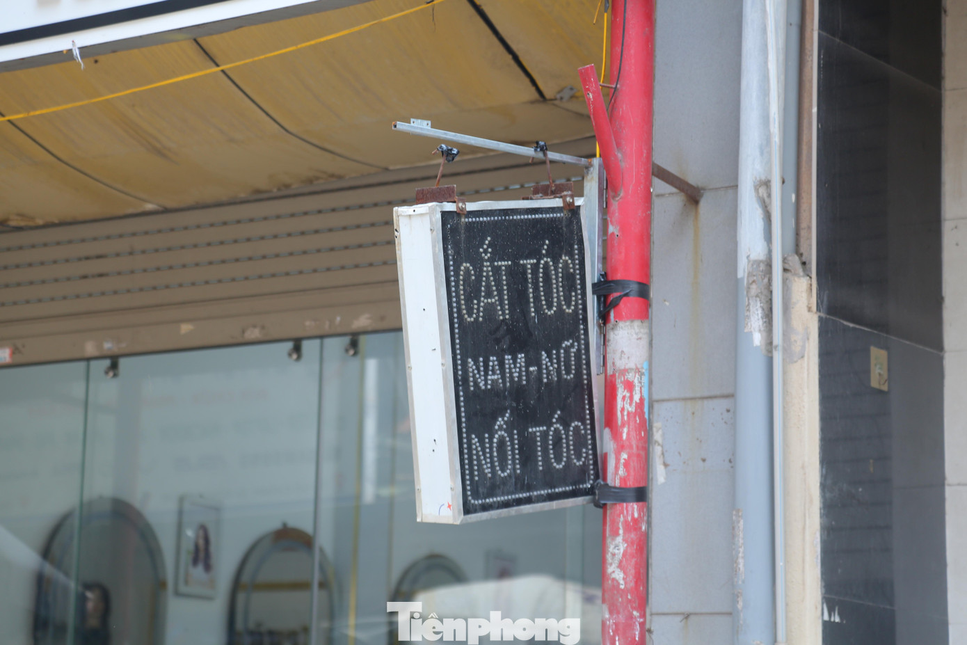 Những cột cũ bị gia cố tận dụng treo biển phụ quảng cáo cho cửa hàng như thế này.