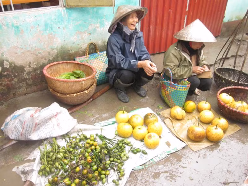 Hai bà lão nông dân bên gánh hàng bưởi và trầu cau ở chợ quê ngày tết