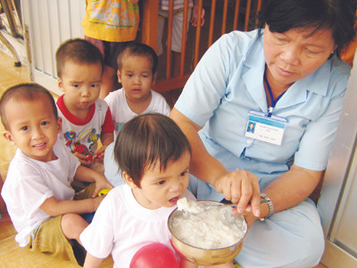 Hộ lý Dương Thị Hường chăm sóc trẻ bị bỏ rơi tại Trung. tâm Ảnh: Kiến Giang. Hộ lý Dương Thị Hường chăm sóc trẻ bị bỏ rơi tại Trung tâm Ảnh: Kiến Giang