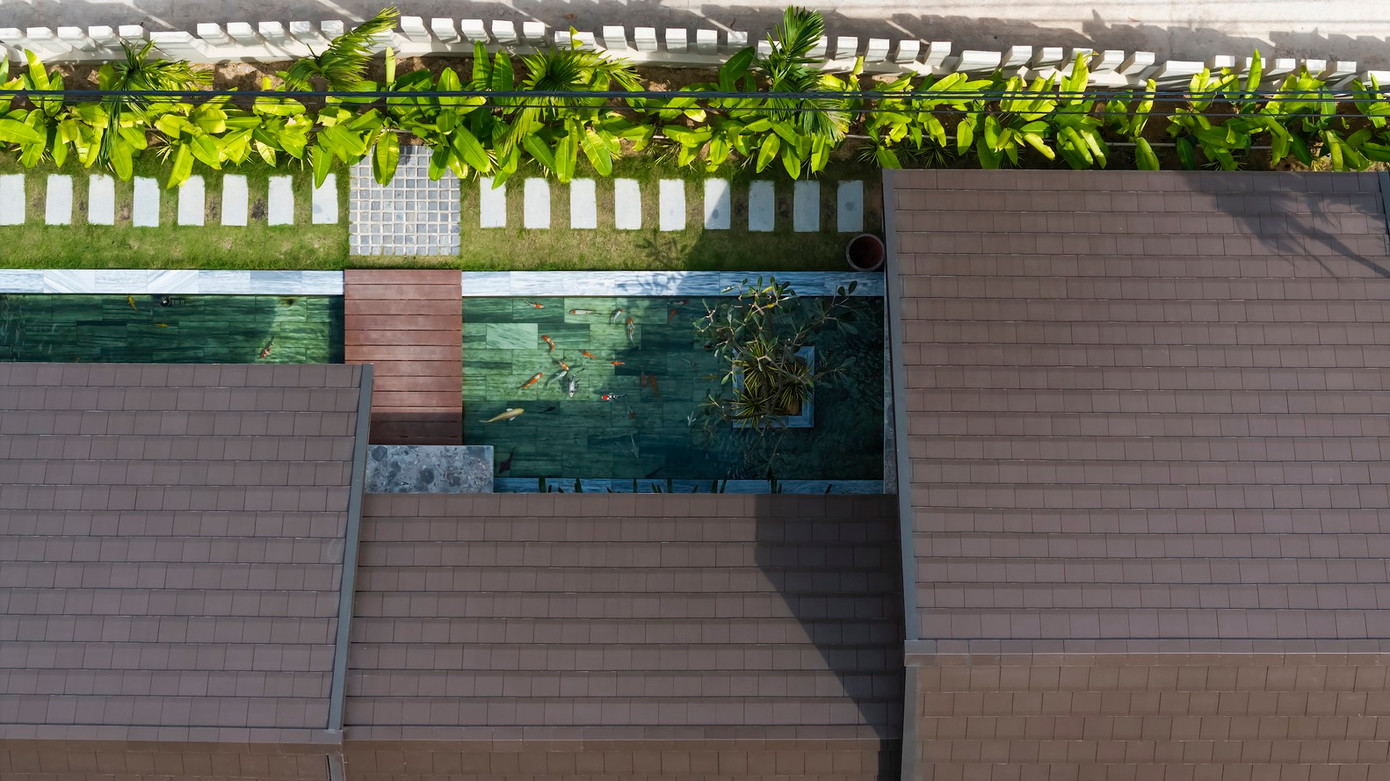 Khác với lối kiến trúc thường thấy, lối vào nhà là qua một hành lang xanh mát và lối đi bằng đá tự nhiên, được trang trí bằng cây xanh và hồ cá Koi, giúp bầu không khí tự nhiên được lưu thông trong khắp ngôi nhà.