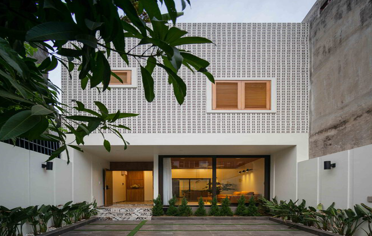 Mặt đứng phía trước sử dụng gạch rỗng với bề mặt lỗ hướng ra ngoài, kết hợp với cửa chớp để đảm bảo sự riêng tư đồng thời đảm bảo thông gió và tầm nhìn vào bên trong. Mặt đứng phía trước sử dụng gạch rỗng với bề mặt lỗ hướng ra ngoài, kết hợp với cửa chớp để đảm bảo sự riêng tư đồng thời đảm bảo thông gió và tầm nhìn vào bên trong.