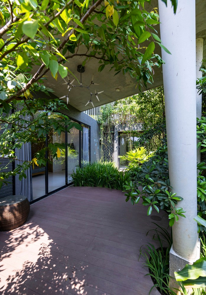 Sân sau có ốc đảo thanh bình với ao cá, hoa và cây bụi được trồng dày đặc. Đây cũng chính là trái tim của ngôi nhà, nơi gia đình dành phần lớn thời gian ở đó. Không gian này thể hiện sự chân thực và thuần khiết của nhà ở truyền thống miền Trung, với mái che tinh xảo gợi lên sự kết nối cảm xúc sâu sắc hơn cho chủ nhân.