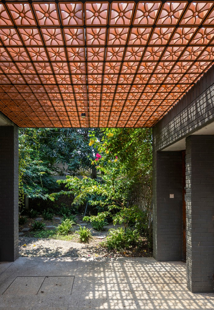 Sân sau có ốc đảo thanh bình với ao cá, hoa và cây bụi được trồng dày đặc. Đây cũng chính là trái tim của ngôi nhà, nơi gia đình dành phần lớn thời gian ở đó. Không gian này thể hiện sự chân thực và thuần khiết của nhà ở truyền thống miền Trung, với mái che tinh xảo gợi lên sự kết nối cảm xúc sâu sắc hơn cho chủ nhân.